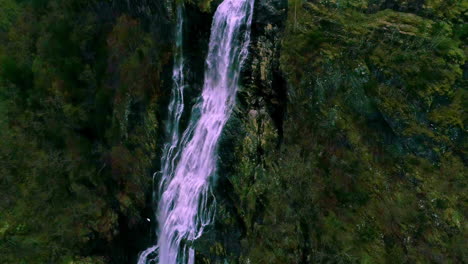 Dron-Aéreo-En-Movimiento-Hacia-Atrás-Sobre-Una-Cascada-Noruega-A-Lo-Largo-De-La-Ladera-De-La-Montaña-Cubierta-De-Vegetación-Verde-Durante-El-Día