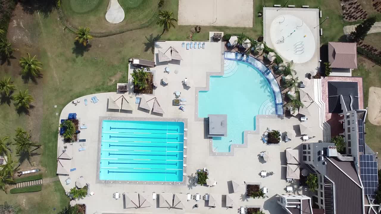 Droneoptagelse fra oven af swimmingpoolen ved Santo Domingo Country Club på en smuk solskinsdag