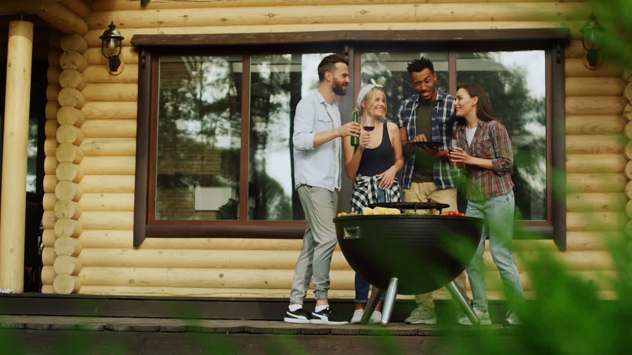 Multiracial friends having rest on party outdoors. People chatting near house