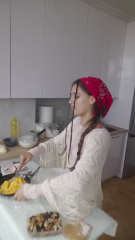 una mujer joven cocinando en una cocina.
