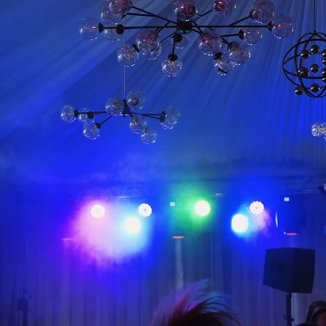 dynamic stage lighting and modern chandeliers in an event venue