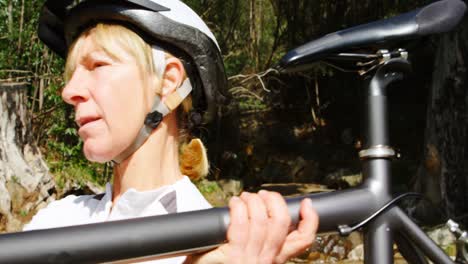 senior cyclist carrying bicycle at countryside 4k