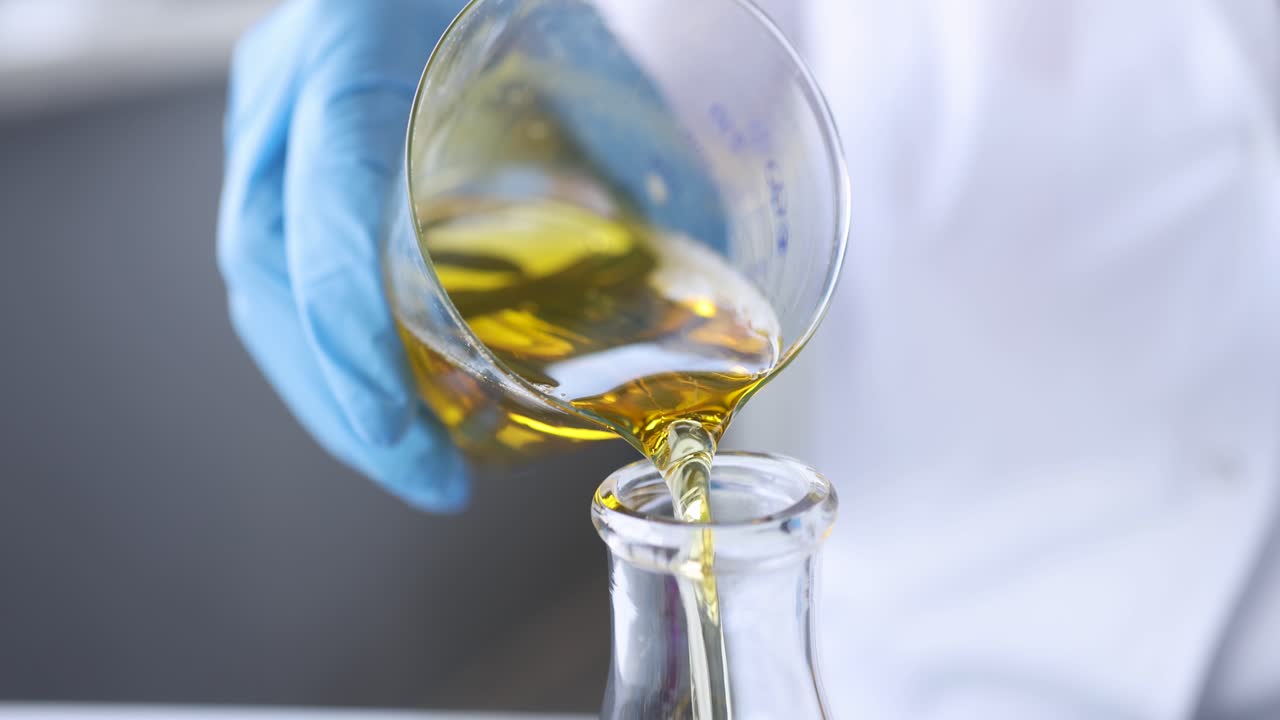 Scientist pouring oil into test tube closeup 4k movie