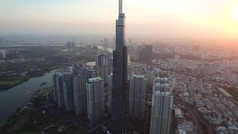 aerial orbiting landmark 81 skyscraper building with city skyline in background at sunset in saigon vietnam