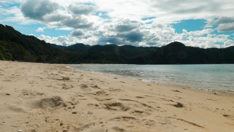 Romantic-shoreline-stroll:-A-couple-walks-on-a-vast-beach