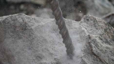 close up of a starting driller digging a hole into a rock in slow motion shorter