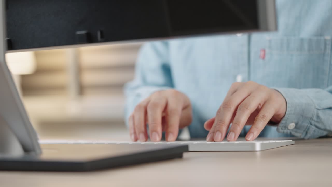 mano de cerca de una mujer de negocios escribiendo teclado computadora de escritorio en la oficina de escritorio
