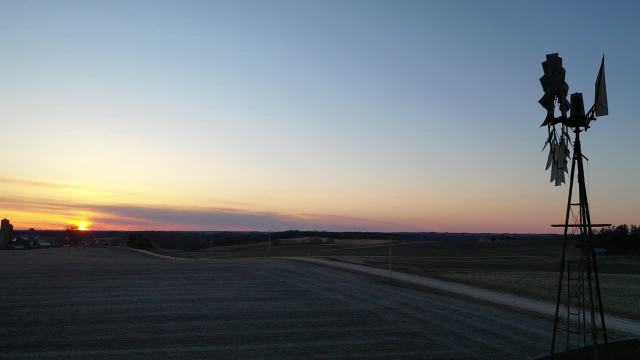 풍차 가 있는 시골 농장 위 의 해가 뜨는 것