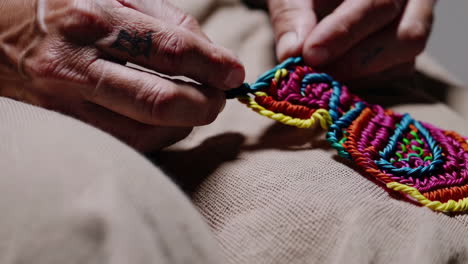 close-up of hands crafting colorful macrame