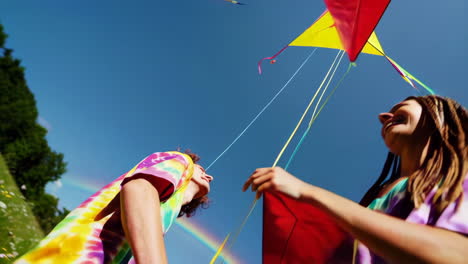 couple flying kites under a rainbow
