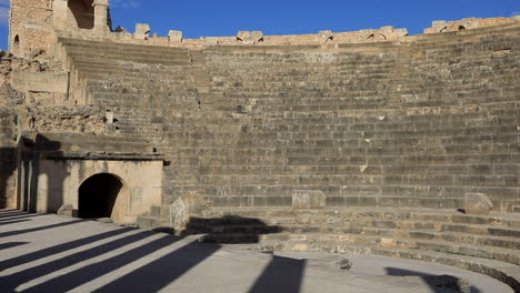 Sonnenlicht-Wirft-Lange-Schatten-In-Den-Antiken-Römischen-Ruinen-Von-Dougga,-Klarer-Blauer-Himmel