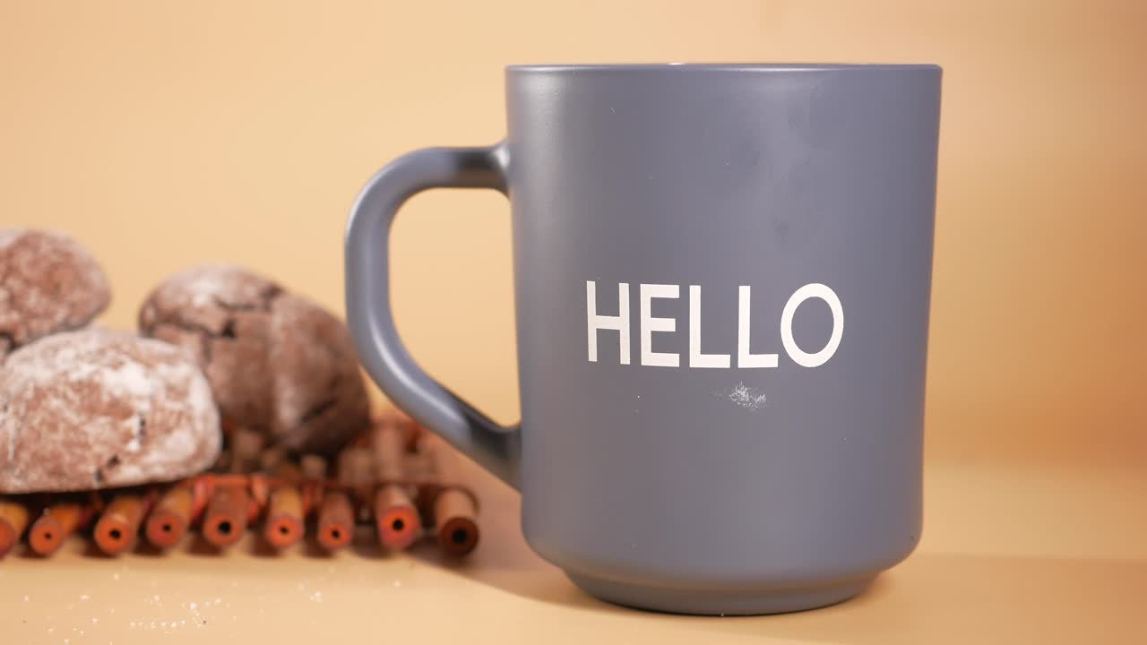 una taza gris con la palabra hola en ella