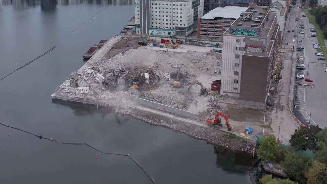 excavadores limpiando escombros y escombros de edificios demolidos junto al agua en liljeholmsviken, liljeholmen, estocolmo, suecia