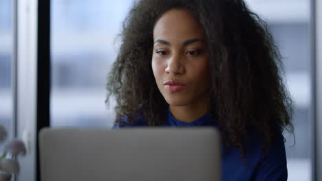 Reflexiva-Mujer-Afroamericana-Ceo-Videollamada-Portátil-Hablando-En-El-Lugar-De-Trabajo.