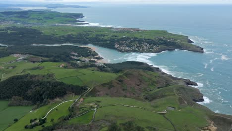 Aerial-high-view-of-Cantabria-Scenic-Coastline-with-the-La-Arena-Beach-in-the-distance,-Spain