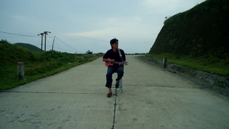 Musician-playing-the-Ukulele-in-the-middle-of-the-road