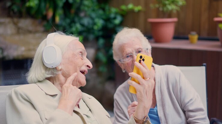 Two Elderly Women Using a Smartphone with Headphones