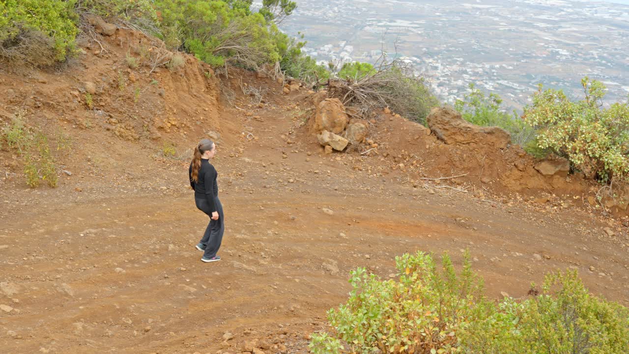 테네리페 의 산 들 에서 길 을 따라 산책 하는 젊은 여자, 뒷면