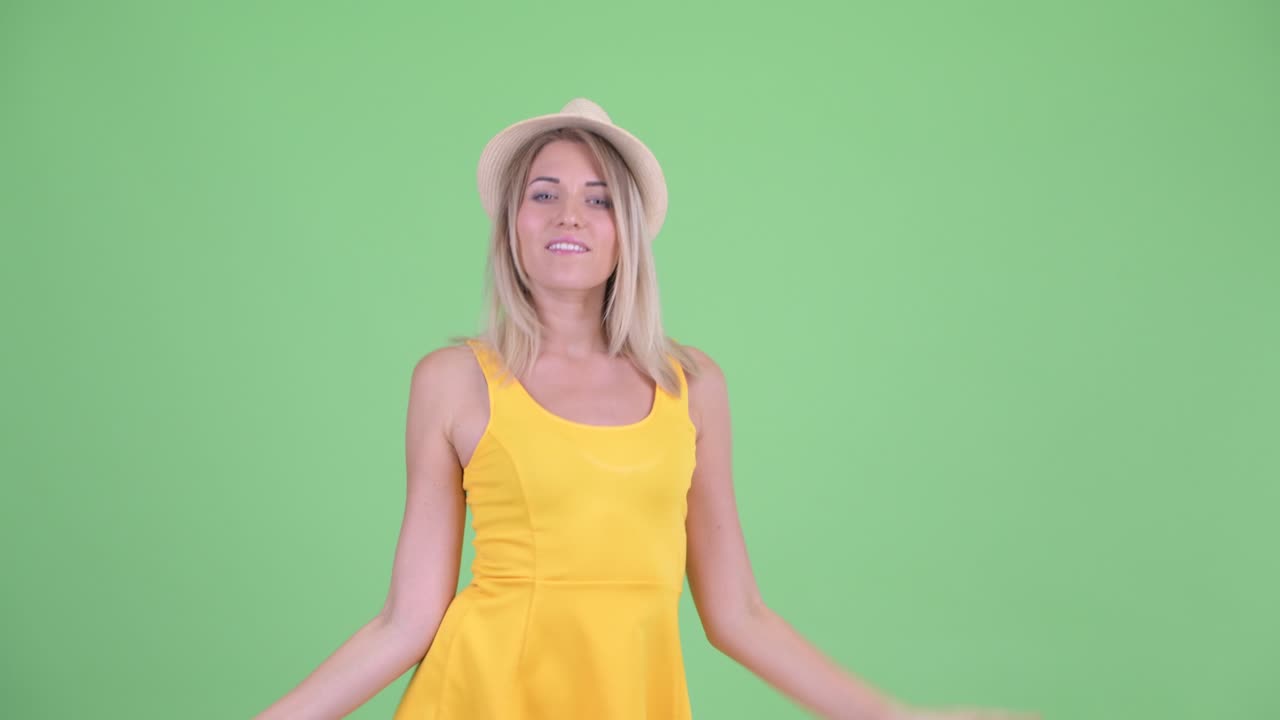 젊은 관광 여성이 초록색 배경에 춤을 추는 스튜디오 촬영