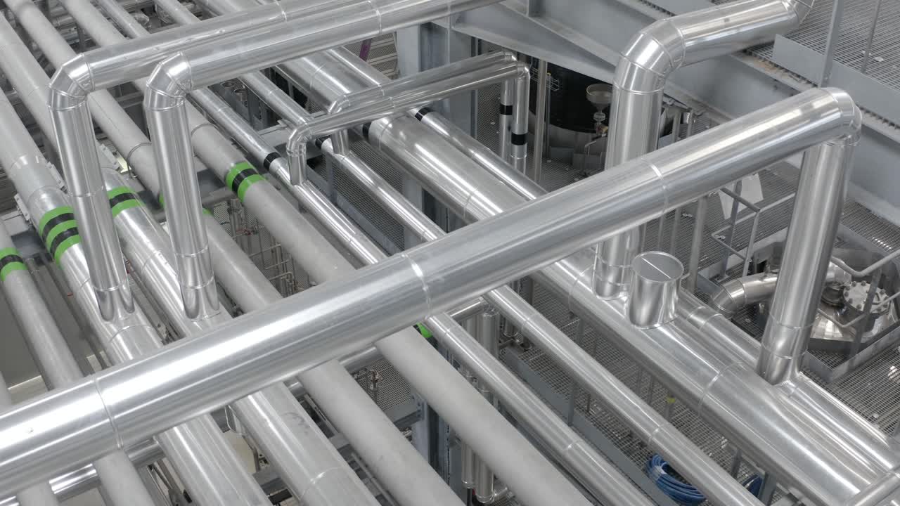 View from above of dense arrangement of silver insulated pipes in modern factory, industrial process, Castets, France