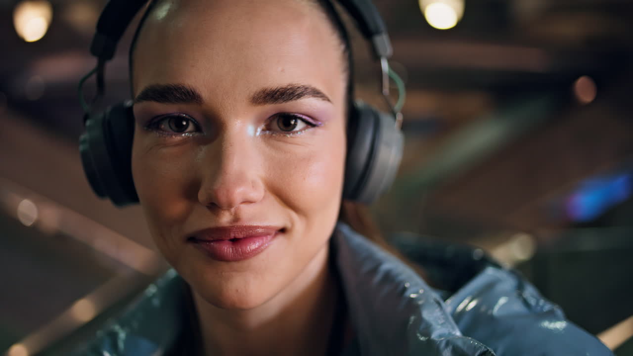 Closeup young woman face with bright makeup wearing wireless headphones.