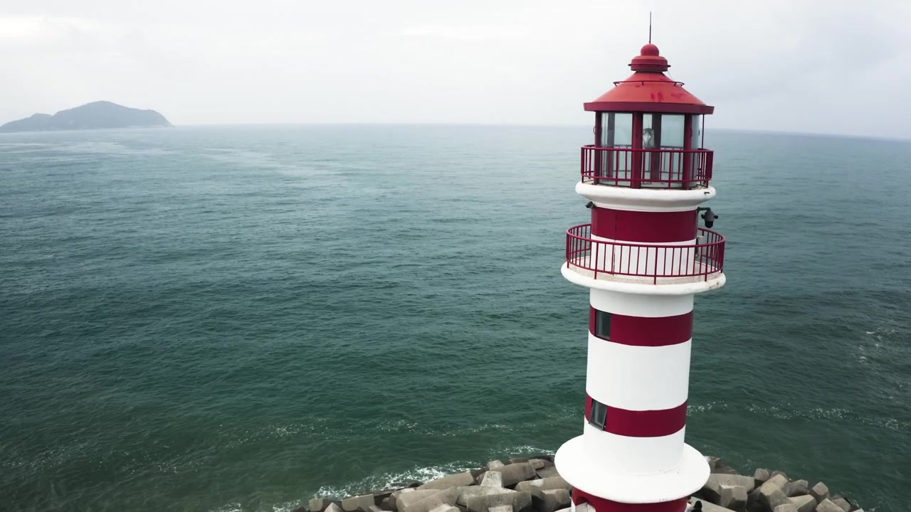 Langsame Drehung um einen Leuchtturm, enthüllt eine Insel in der Ferne.