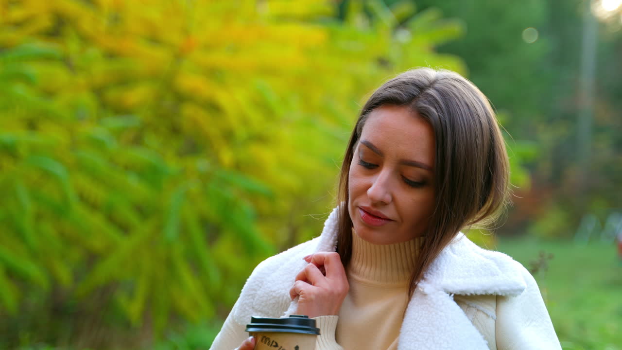 Woman drinking coffee in an autumn park