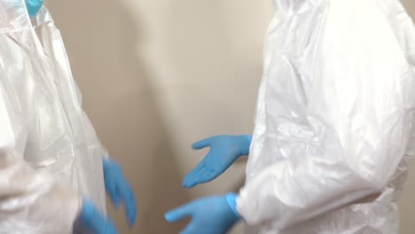 doctors in protective suit ppe making a salute with their fists gesturing and talking