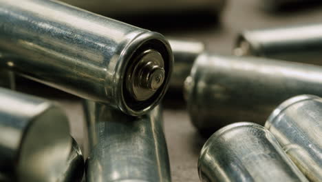 Silver batteries AA and AAA on black background close-up. Double-A battery is a standard size single cell cylindrical dry battery. Batteries are common in portable electronic devices. An AA battery is composed of a single electrochemical cell that may be either a primary battery or a rechargeable ba