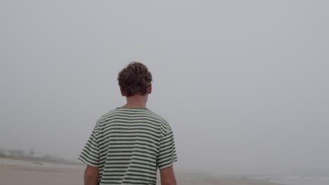 man walking on a foggy beach