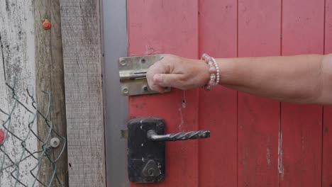 a person unlocking a wooden door on the farm, capturing a simple yet meaningful moment of daily farm life. a rustic scene highlighting the hands-on work of rural living.