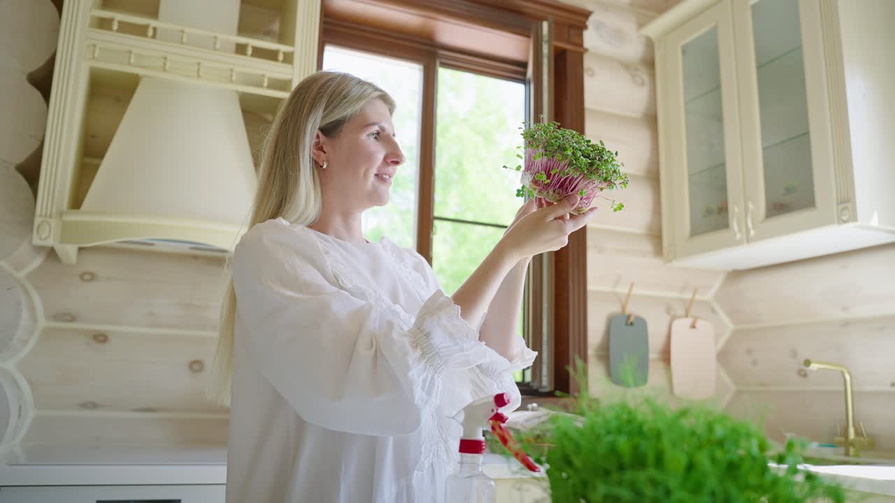 Woman admiring her homegrown microgreens in a kitchen