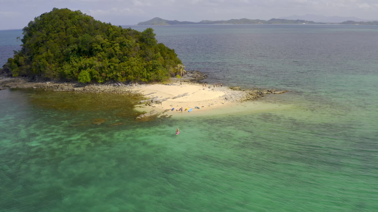 Aerial View of Tropical Island with Turquoise Waters and People on the Beach