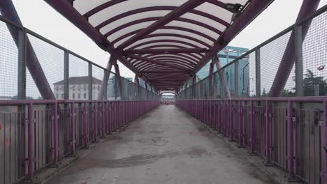 moody pedestrian bridge over railway in milan, handheld view