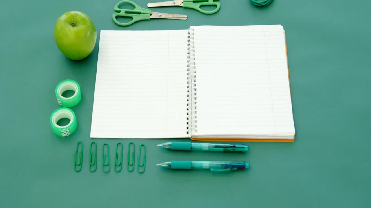 manzana y suministros de oficina en fondo verde 4k