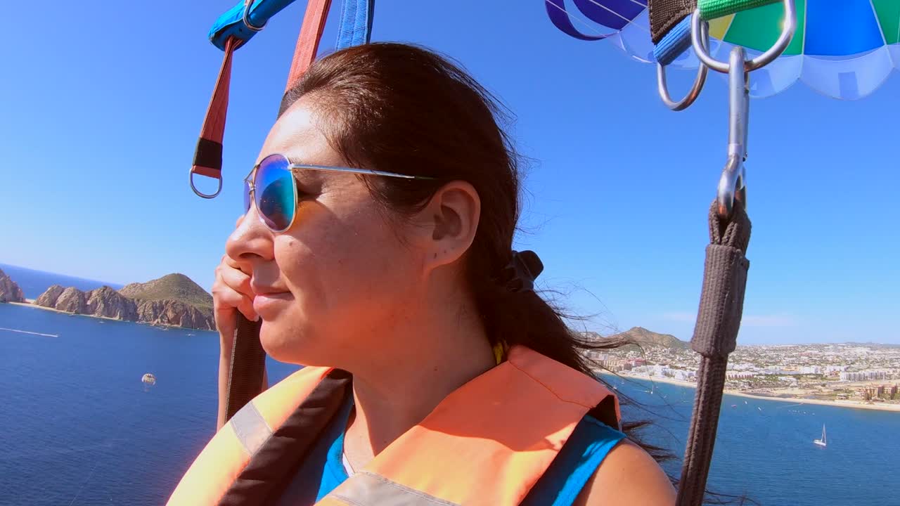 hermosa chica parapente alto sobre el océano en cabo san lucas, méxico