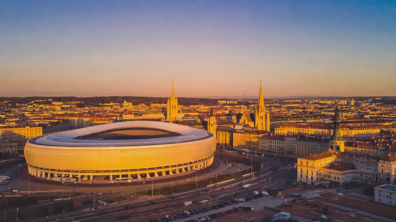 Aerial View of a Modern Stadium and City Skyline at Sunrise or Sunset