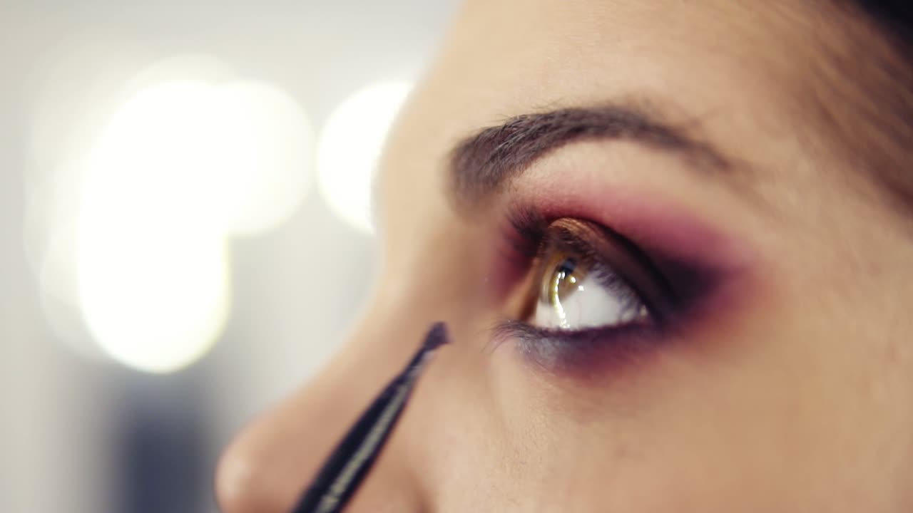 cerrar imágenes ligeramente desenfocadas de la aplicación y la mezcla de sombras de ojos. proceso de creación de ojos de humo impecable maquillaje mirar.