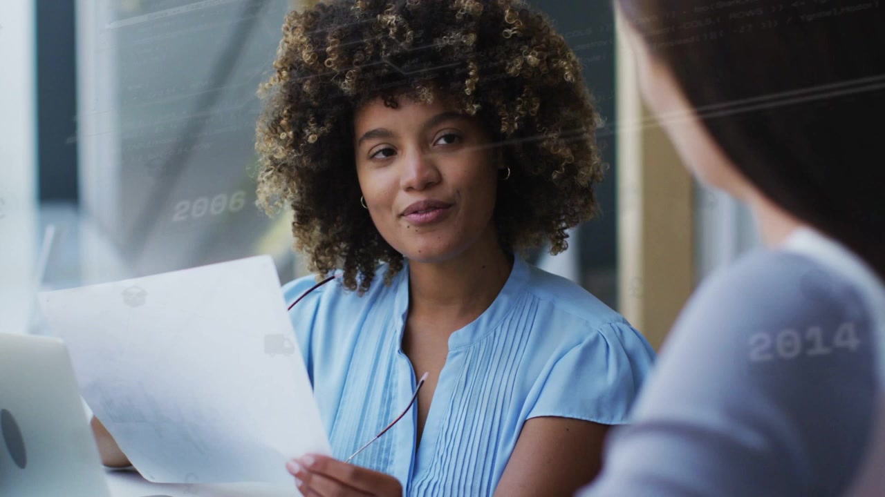 Blue data overlay appearing, fading, woman raising specs, reading report, briefing peer in business