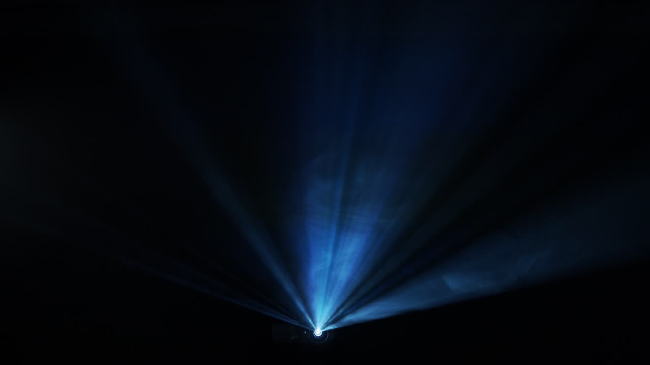 el haz del proyector atraviesa la niebla en un concierto
