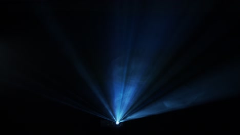 projector beam cuts through fog at a concert