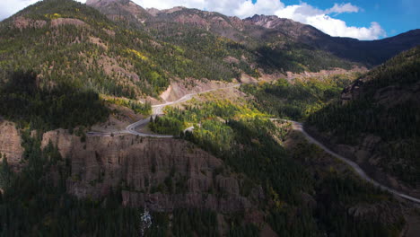 Vista-Aérea-Del-Paso-De-Montaña-De-Wolf-Creek-Bajo-Las-Sombras-De-Las-Nubes,-Camino-Con-Curvas-Y-Mirador,-Colorado,-EE.UU.