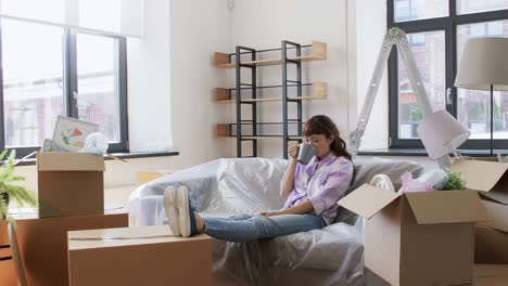 mujeres que se mudan a una nueva casa y beben café. gente, reparación y concepto de bienes raíces mujeres sonrientes con cosas que se mueven a una nuevo casa, beben café o té y hablan