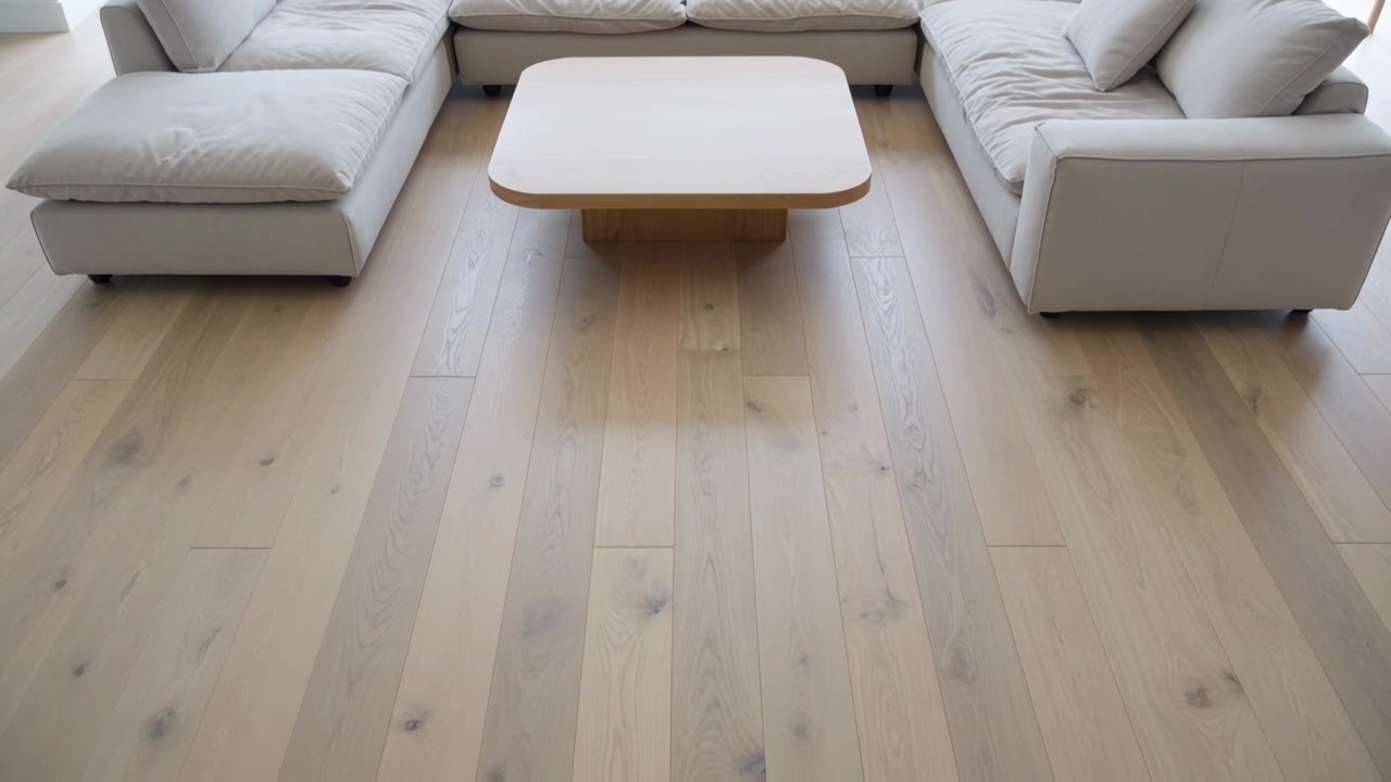Bewegte Kamera zentriert hölzernen Couchtisch im Wohnzimmer auf breitem Eichenboden, das Sofa betonend.
