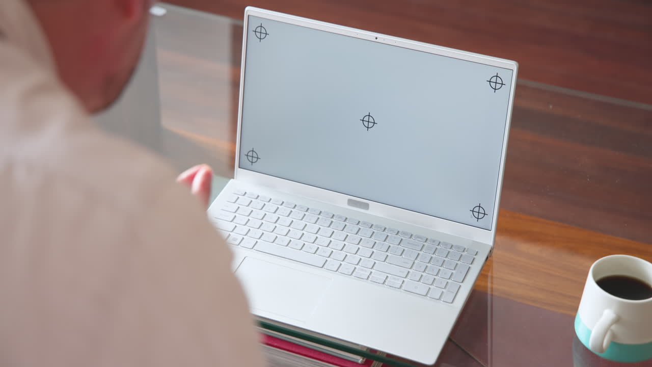 Senior man using laptop at home with coffee on table, focusing on screen, copy space