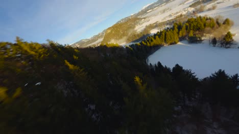 fpv drone shot, the landscape covered under the fog with surrounding mountains in the morning at winter time in slovenia captured in 4k, drone flying fast, close to objects with lots of movement