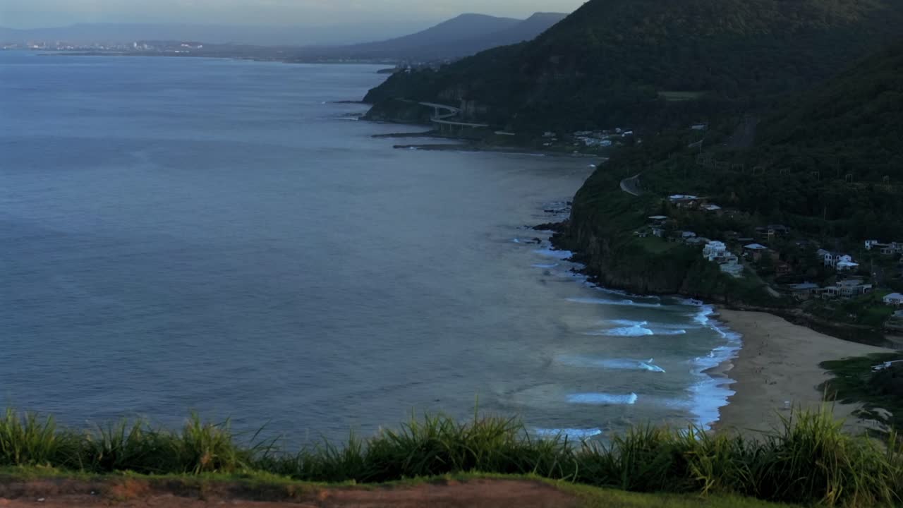 puente del acantilado marino vista de la playa de stanwell park cimas de la colina calva drone aéreo amanecer puesta de sol hora dorada azul wollongong nsw australia sydney costa sur illawarra coalcliff garganta lenta pan hacia adelante