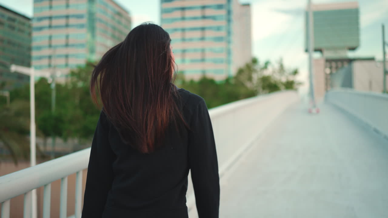 Mulher caminhando em uma ponte na cidade