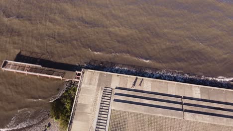 people walking along river on concrete pavement edge with geometric shapes, buenos aires in argentina