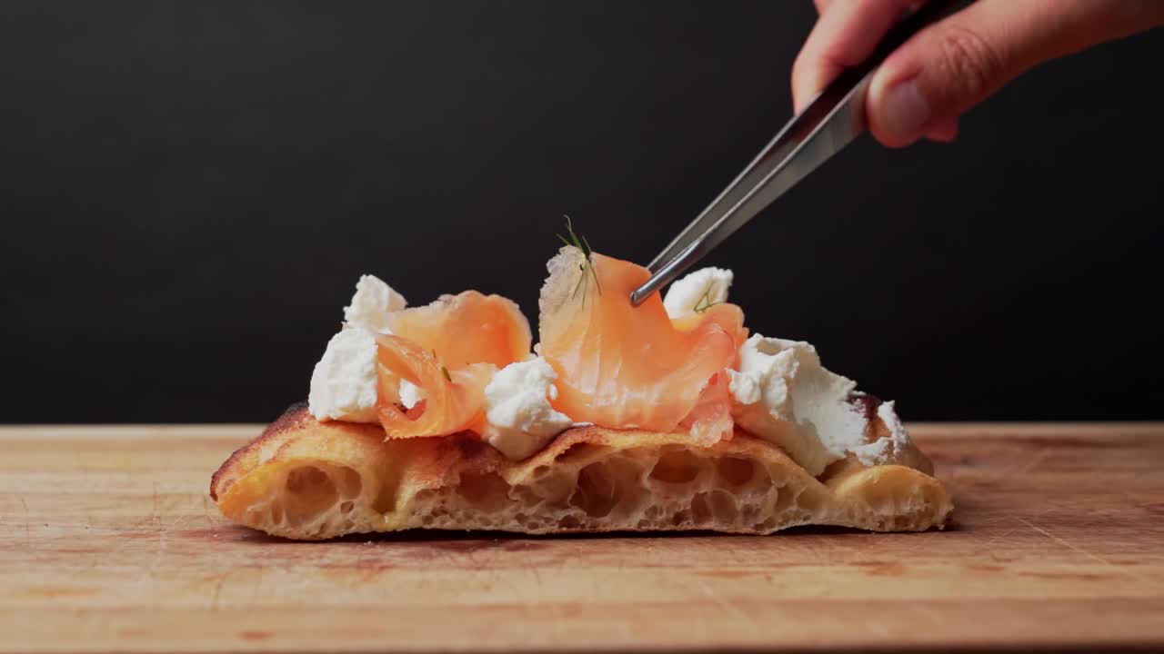 맛있는 레스토랑 셰프는 피자 반죽에 정확하게 두 번째 연어를 배치합니다.